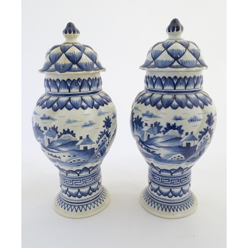 46 - Two blue and white ginger jars decorated with buildings in a landscape, and banded petal and geometr... 