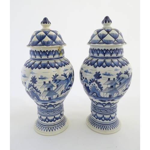 46 - Two blue and white ginger jars decorated with buildings in a landscape, and banded petal and geometr... 