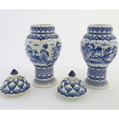 46 - Two blue and white ginger jars decorated with buildings in a landscape, and banded petal and geometr... 