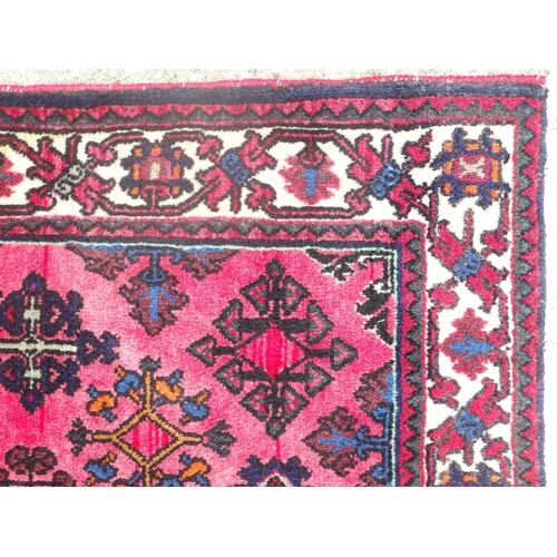 516 - Carpet / rug : a hand woven woollen rug with red central ground and 78 diamond shaped decorations to... 