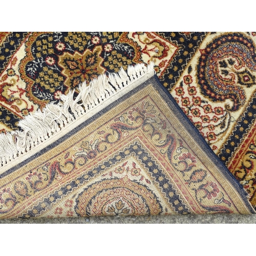 519 - Rug / Carpet: a large handmade woollen carpet, having mustard, black, yellow, red, cream etc. colour... 