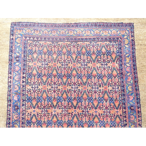 520 - Carpet / Rug : a hand woven Signed Runner with a red central ground, blue, navy blue, pink, black an... 