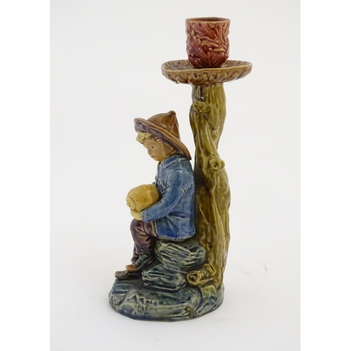 61 - A continental candlestick decorated with a fisherman boy holding a nautilus shell. Stamped under 'BD... 