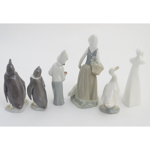 76 - A quantity of Lladro and Nao figures, to include two Lladro penguins and girl holding a chicken, a N... 