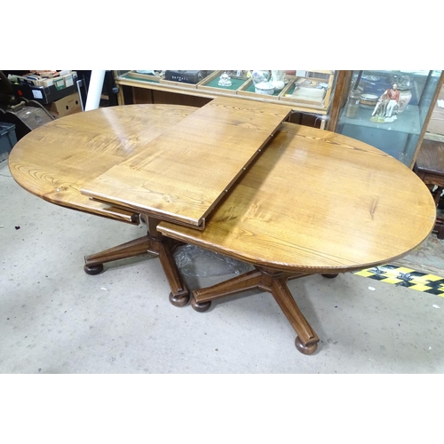 121 - An extended oak pedestal table with 1 leaf and 2 pedestals