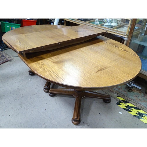 121 - An extended oak pedestal table with 1 leaf and 2 pedestals