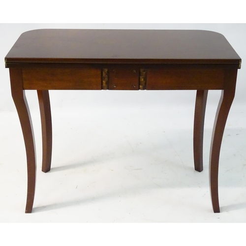 137 - An early 21stC mahogany tea table with Sheraton revival motifs and standing on fluted cabriole legs.... 