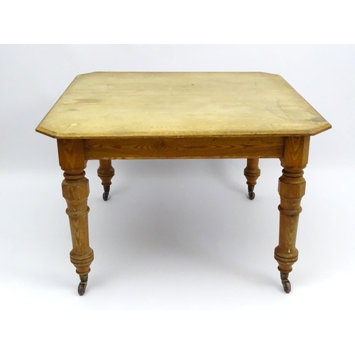 140 - An early 20thC ash dining table with chamfered and baluster turned legs terminating in ceramic casto... 