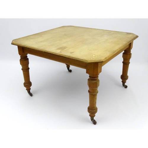 140 - An early 20thC ash dining table with chamfered and baluster turned legs terminating in ceramic casto... 