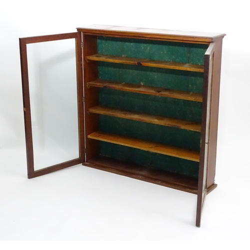 154 - An early 20thC mahogany bookcase with a moulded top, two glazed doors and four adjustable shelves wi... 