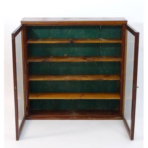 154 - An early 20thC mahogany bookcase with a moulded top, two glazed doors and four adjustable shelves wi... 