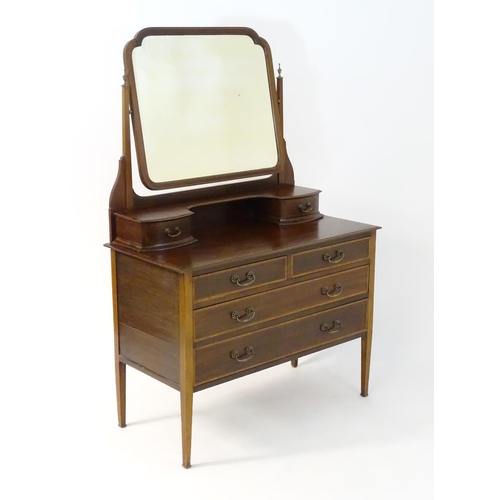 181 - An early 20thC mahogany dressing table, having a bevelled mirror and two short drawers above, the ba... 