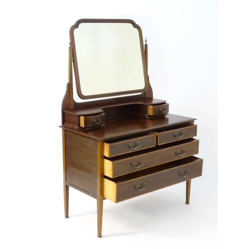 181 - An early 20thC mahogany dressing table, having a bevelled mirror and two short drawers above, the ba... 