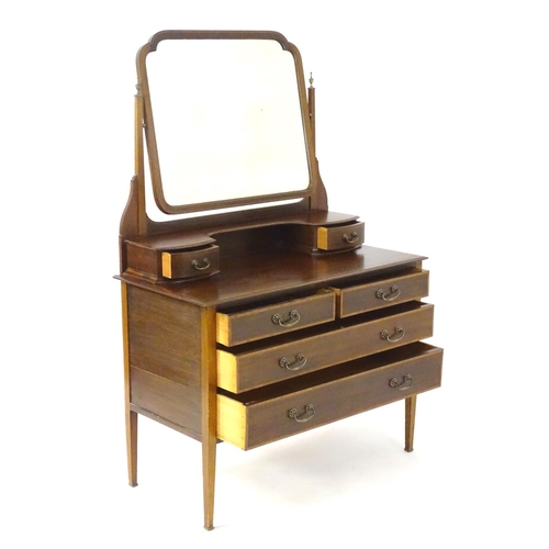 181 - An early 20thC mahogany dressing table, having a bevelled mirror and two short drawers above, the ba... 