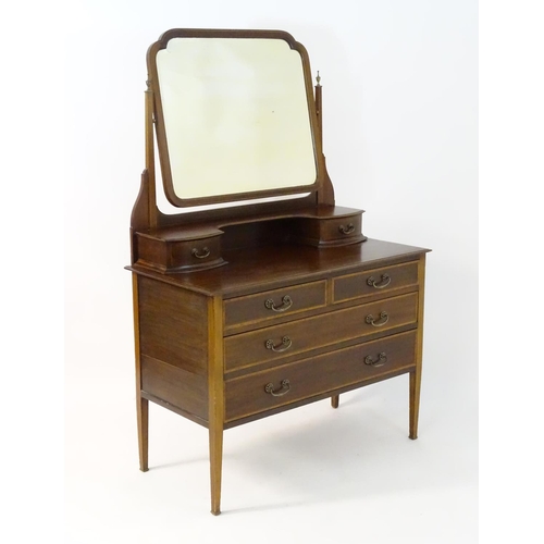 181 - An early 20thC mahogany dressing table, having a bevelled mirror and two short drawers above, the ba... 