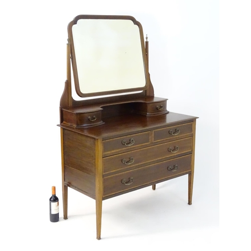 181 - An early 20thC mahogany dressing table, having a bevelled mirror and two short drawers above, the ba... 