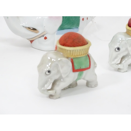 298 - A pair of mid 20thC elephant pin cushions, decorated in polychrome, together with a mid 20thC elepha... 