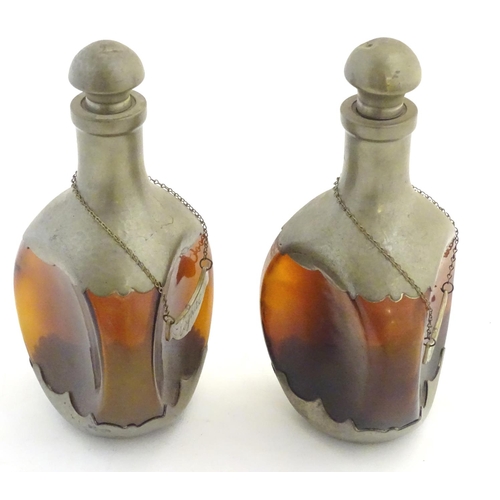 392 - A pair of dimple like brown glass and pewter mounted decanters with bottle tags marked 'Cognac' & 'W... 