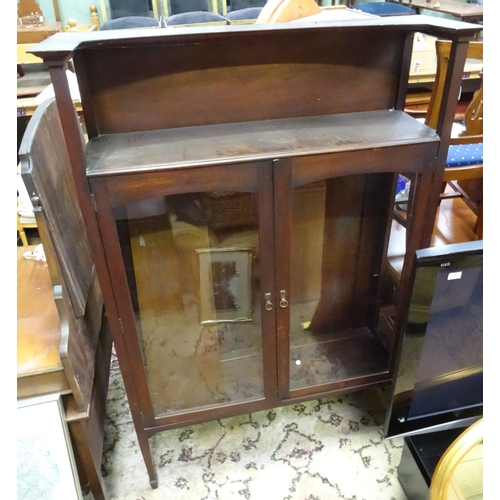 411 - Arts & Crafts - A late 19thC / early 20thC walnut glazed cabinet with gallery above and raised on ta... 