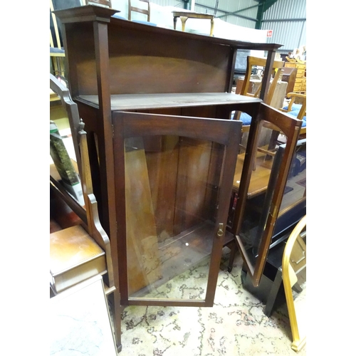 411 - Arts & Crafts - A late 19thC / early 20thC walnut glazed cabinet with gallery above and raised on ta... 