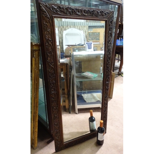 555 - A mirror with a carved oak frame