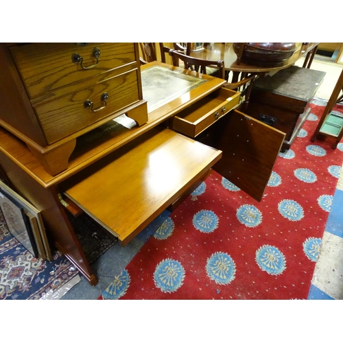 64 - An oak veneered and leather topped office desk with a pull out section for a keyboard, together with... 