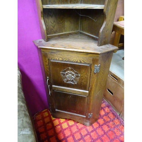 74 - An oak corner cupboard with rose detail