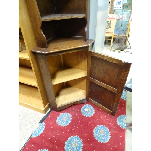 74 - An oak corner cupboard with rose detail