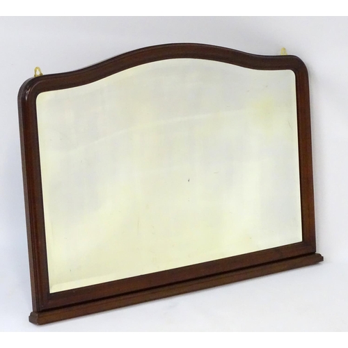 80 - A 20thC mahogany mantle mirror with bevelled edge, shaped top and a stepped base. 45'' wide x 32'' h... 