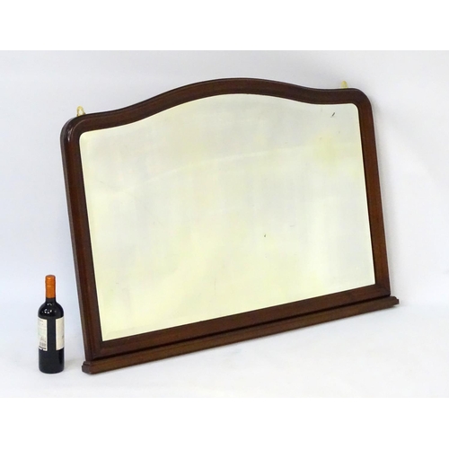 80 - A 20thC mahogany mantle mirror with bevelled edge, shaped top and a stepped base. 45'' wide x 32'' h... 