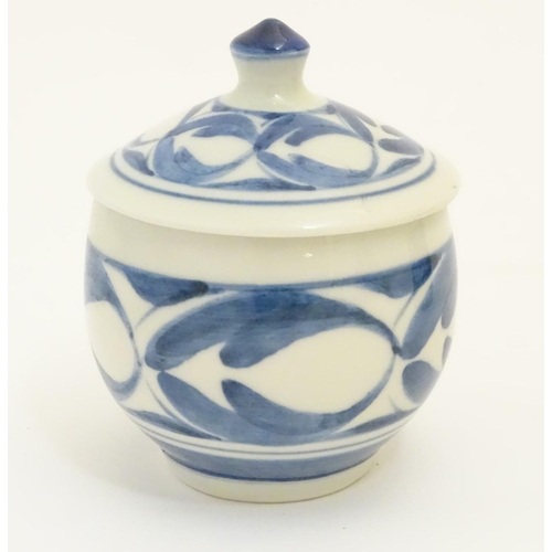 102 - A Derek Emms studio pottery lidded preserve pot, with blue and white stylised foliage decoration. In... 