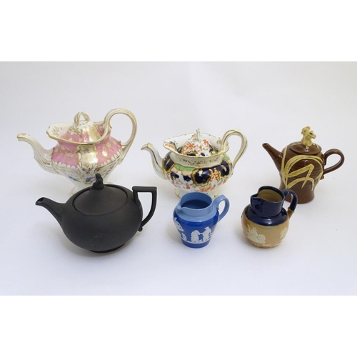 106 - A quantity of assorted teapots, to include a Wedgwood black basalt teapot with a female figural fini... 