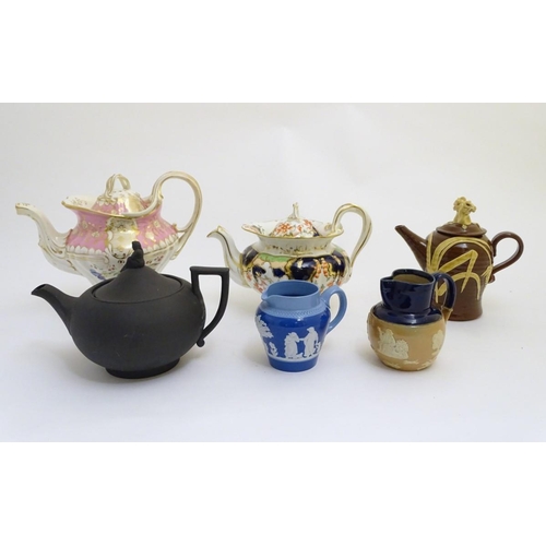 106 - A quantity of assorted teapots, to include a Wedgwood black basalt teapot with a female figural fini... 