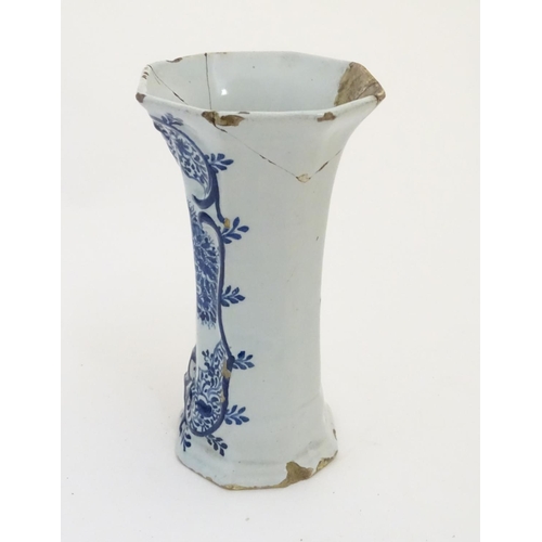 112 - An 18thC Delft blue and white octagonal vase with a flared rim, decorated with a vase of flowers and... 