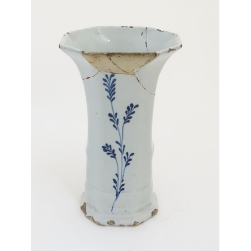 112 - An 18thC Delft blue and white octagonal vase with a flared rim, decorated with a vase of flowers and... 