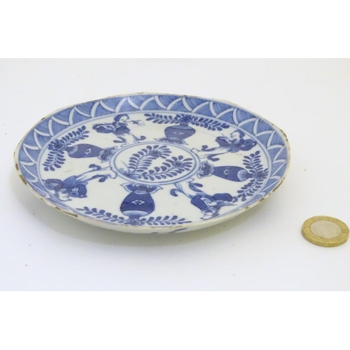 113 - A Chinese blue and white dish decorated with four baluster vases, four figures with attributes such ... 