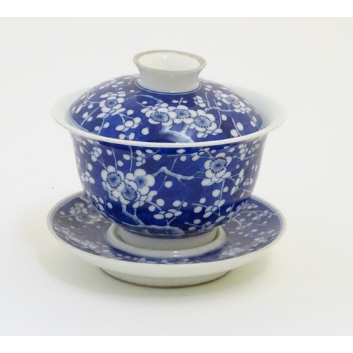 14 - A Chinese blue and white tea bowl, lid and saucer, decorated with cherry blossom. Character marks un... 