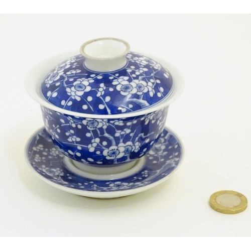 14 - A Chinese blue and white tea bowl, lid and saucer, decorated with cherry blossom. Character marks un... 