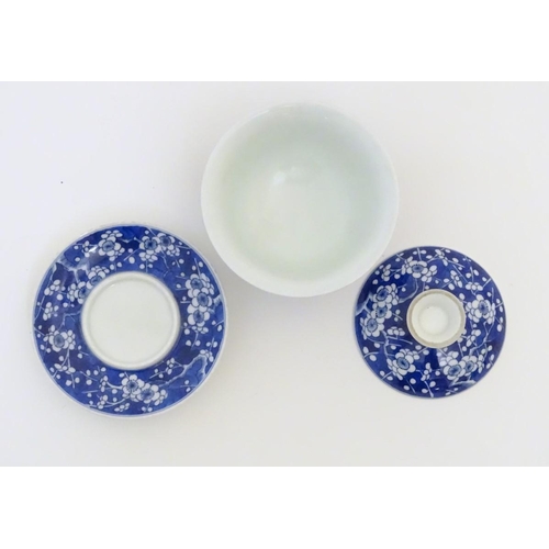 14 - A Chinese blue and white tea bowl, lid and saucer, decorated with cherry blossom. Character marks un... 