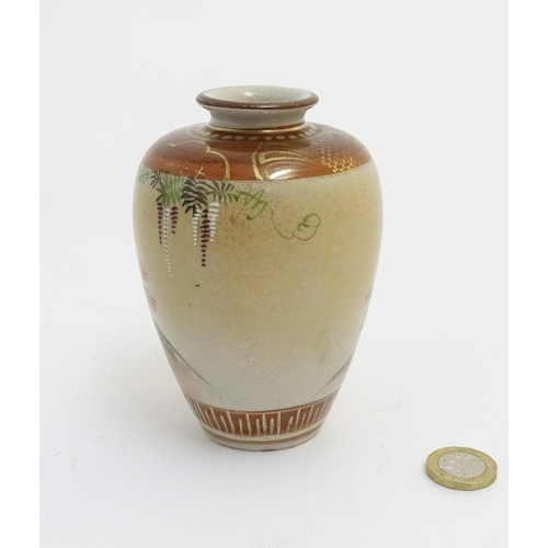 15 - A small Japanese satsuma vase depicting figures in a garden, with gilt highlights. Character marks t... 