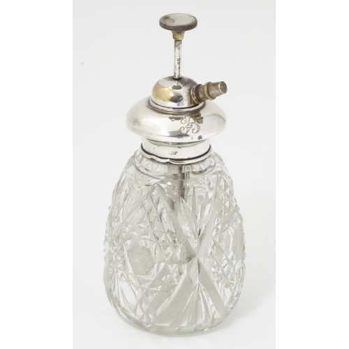 167 - A cut glass scent / perfume bottle with Sterling silver mount and atomiser top. 5 1/2'' high