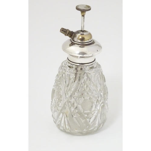 167 - A cut glass scent / perfume bottle with Sterling silver mount and atomiser top. 5 1/2'' high