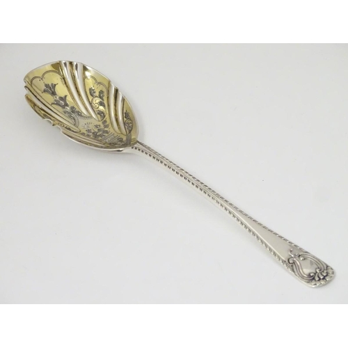 171 - An Edwardian silver serving spoon, having engraved decoration to fluted bowl hallmarked London 1904 ... 