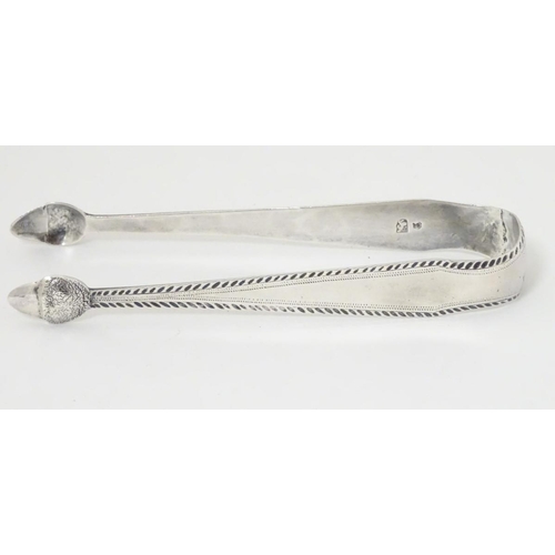 175 - Geo III silver sugar tongs with bright cut decoration and acorn formed grips. With incuse duty mark.... 