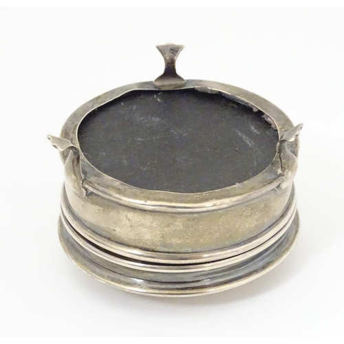 178 - A silver ring box with engine turned decoration and standing on three feet. Hallmarked Birmingham 19... 