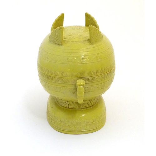 19 - A Chinese yellow ground lidded pot raised on a foot, with twin handles formed as stylised elephant h... 