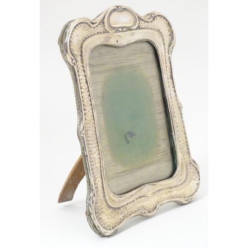 194 - An Art Nouveau silver photograph frame with hammered decoration. Hallmarked Birmingham 1903 maker He... 