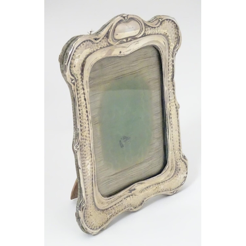 194 - An Art Nouveau silver photograph frame with hammered decoration. Hallmarked Birmingham 1903 maker He... 