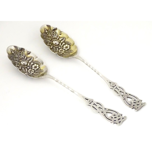 205A - A pair of silver plate berry spoons with open work decoration to handles. 8 1/4'' long