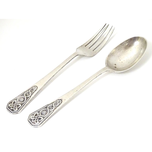 211 - A silver christening spoon and fork with Celtic decoration to handles. Hallmarked Sheffield 1948 / 1... 